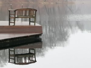 Eine leere Bank auf einer Badeplattform auf dem Huwenowsee bei Meseberg.